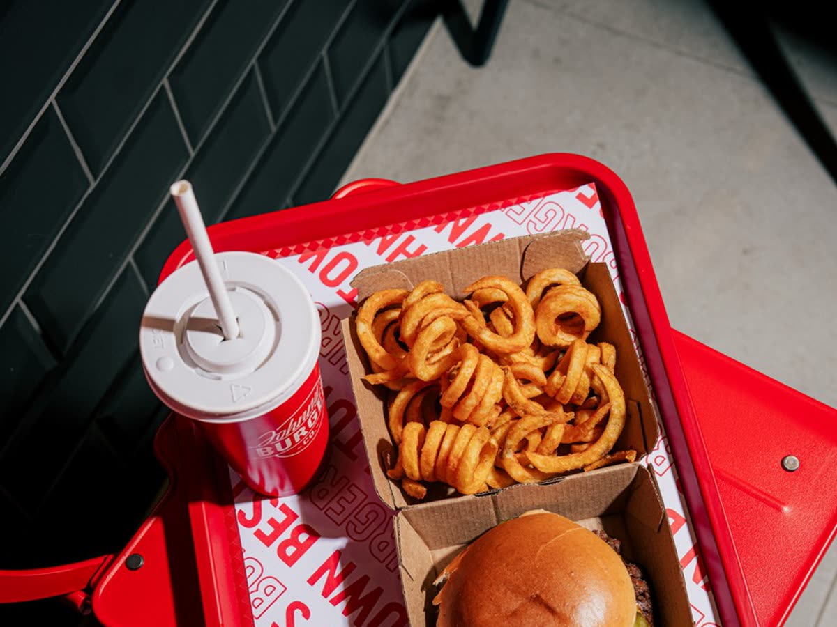 Een dienblad van Johnny's met een burger in een doosje, Twister Fries en een beker frisdrank.